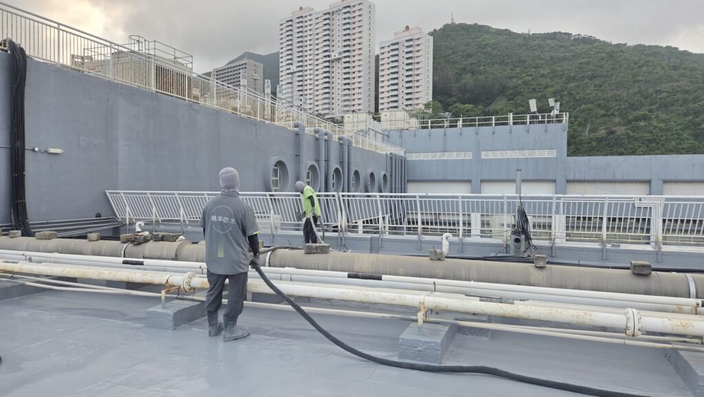 柴灣IVE 天台防水工程- 完成塗刷專用環氧底漆工序後，師傅操作高壓熱噴塗聚脲設備進行天台POLYUREA聚脲 防水層噴塗